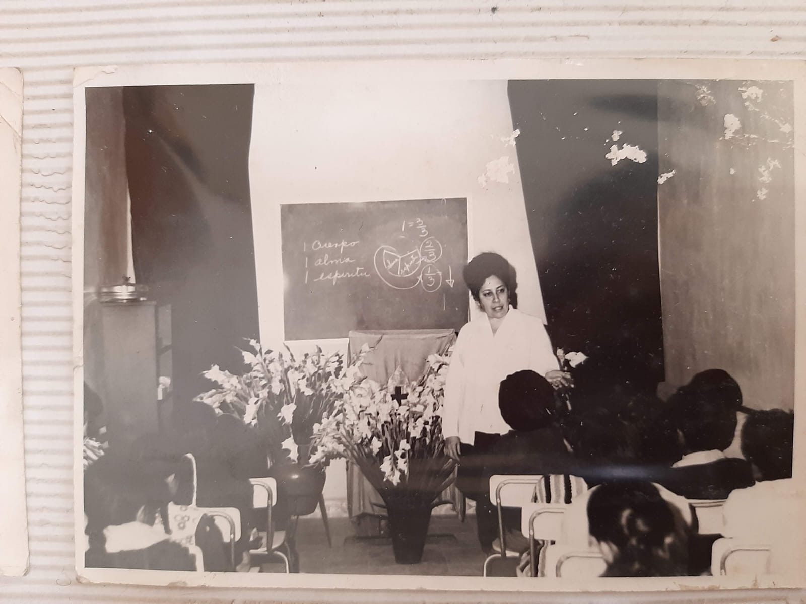 Fotografía histórica de una mujer compartiendo la Palabra ante la congregación